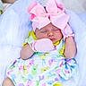 baby, sleeping, pink_bow, mittens, colorful_clothing, bunny_pattern, yellow_shorts, white_socks, soft_fabric, newborn, cute, peaceful, infant, headband, portrait, child, resting, adorable, one_person, indoors