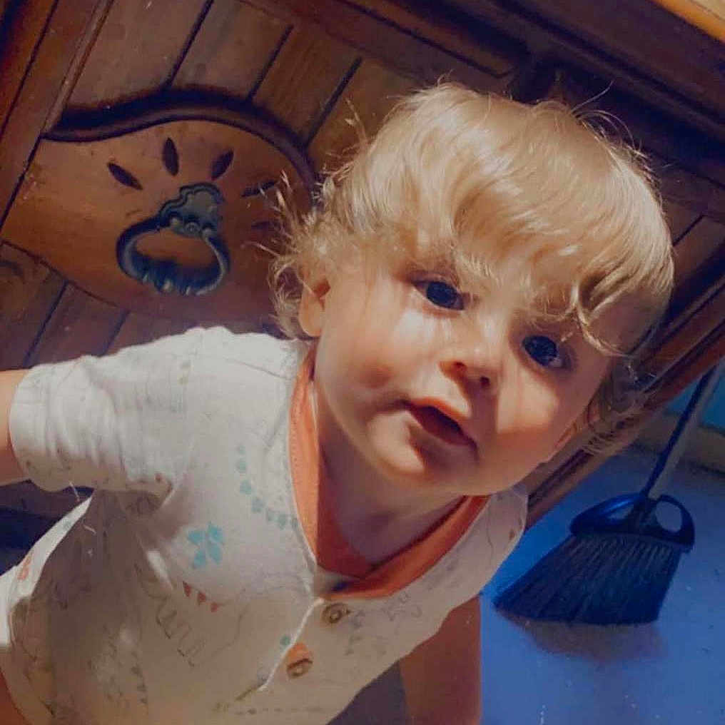 Sawyer Breaux is registered to the contest to win money with this photo: baby, barefoot, blonde_hair, broom, cabinet, carpet, child, clothing, curious, curly_hair, exploring, face, floor, furniture, hand, indoor, person, portrait, toddler, young_child