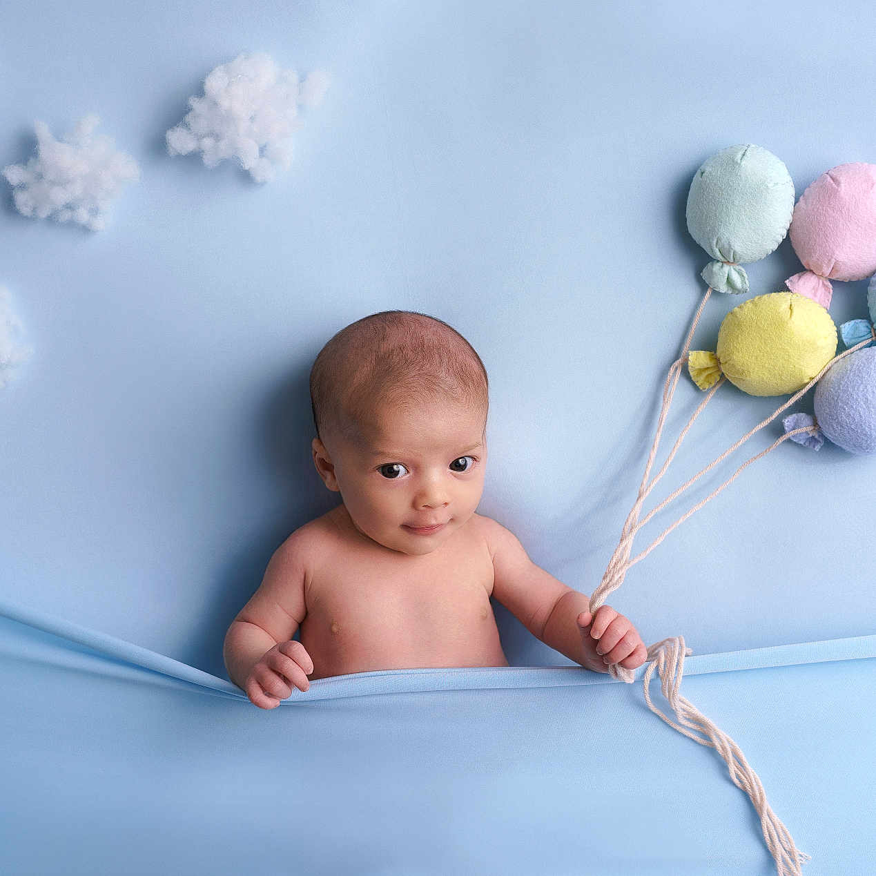 Salomé a rejoint le concours — aidez-le/la à gagner de superbes lots ! baby, blanket, blue_background, child, cotton_clouds, cute, decor, fabric, happy, holding, indoors, infant, playful, plush_balloons, portrait, smiling, soft_texture, studio_photo, toy, young_child