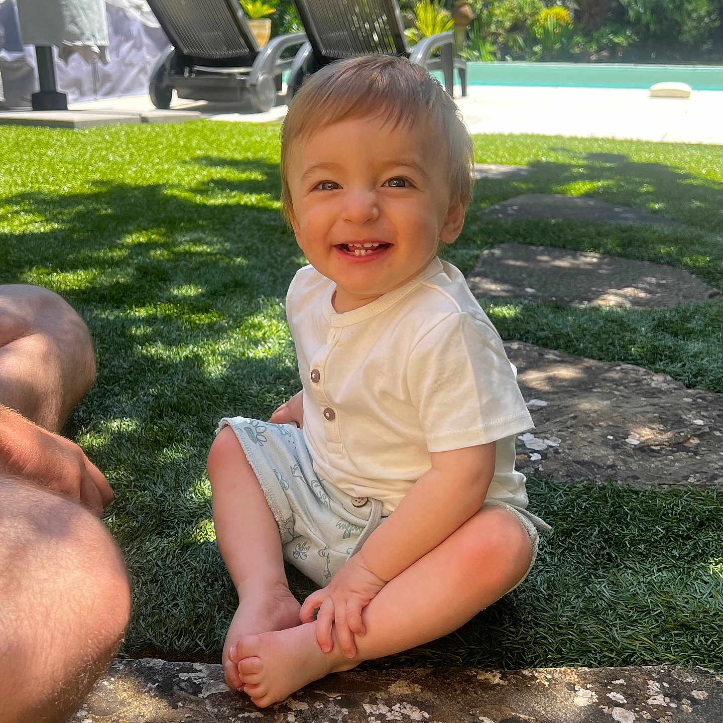 Maylone participe au concours pour gagner de l'argent avec cette photo : barefoot, child, cute, daytime, garden_chair, grass, happy, leisure, nature, outdoor, person, playful, pool, shorts, sitting, smiling, summer, sunlight, toddler, white_shirt