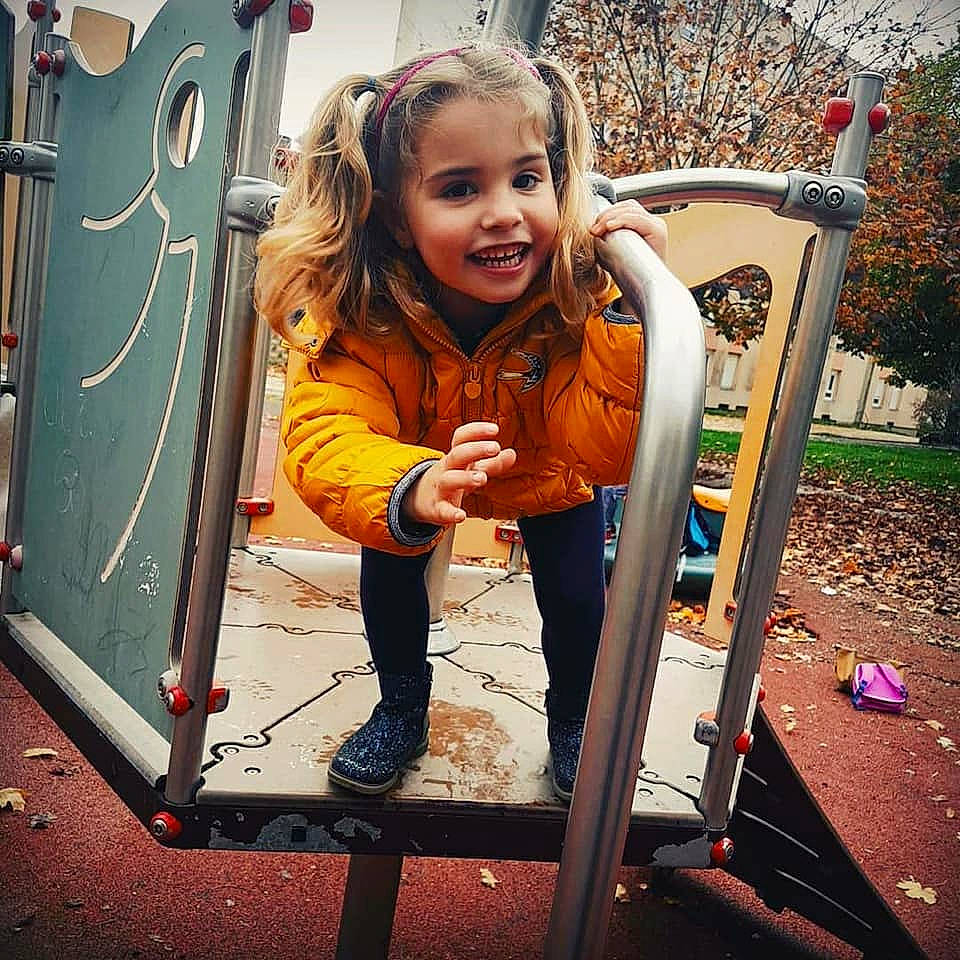 Célya participe au concours pour gagner de l'argent avec cette photo : child, facial_expression, fun, girl, hair, happiness, human_body, joy, outdoor_play_equipment, person, play, playground, product, public_space, recreation, sitting, smile, standing, toddler