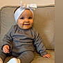 baby, infant, child, headband, bow, smile, sitting, couch, sofa, grey_outfit, white_shoes, indoor, portrait, cute, happy, one_person, hands, feet, cozy, soft_tones