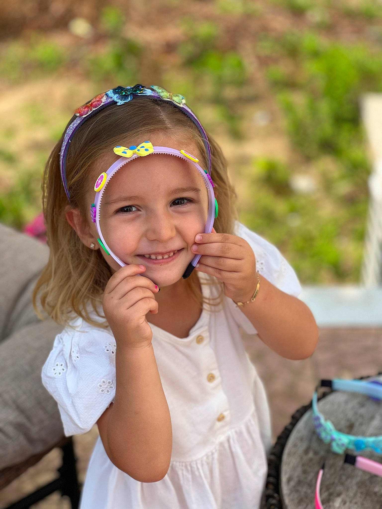 Adora is registered to the contest to win money with this photo: beauty, child, facial_expression, fashion, fun, grass, hairstyle, happy, headband, headpiece, headwear, iris, jewellery, joy, leisure, people_in_nature, person, personal_protective_equipment, recreation, skin