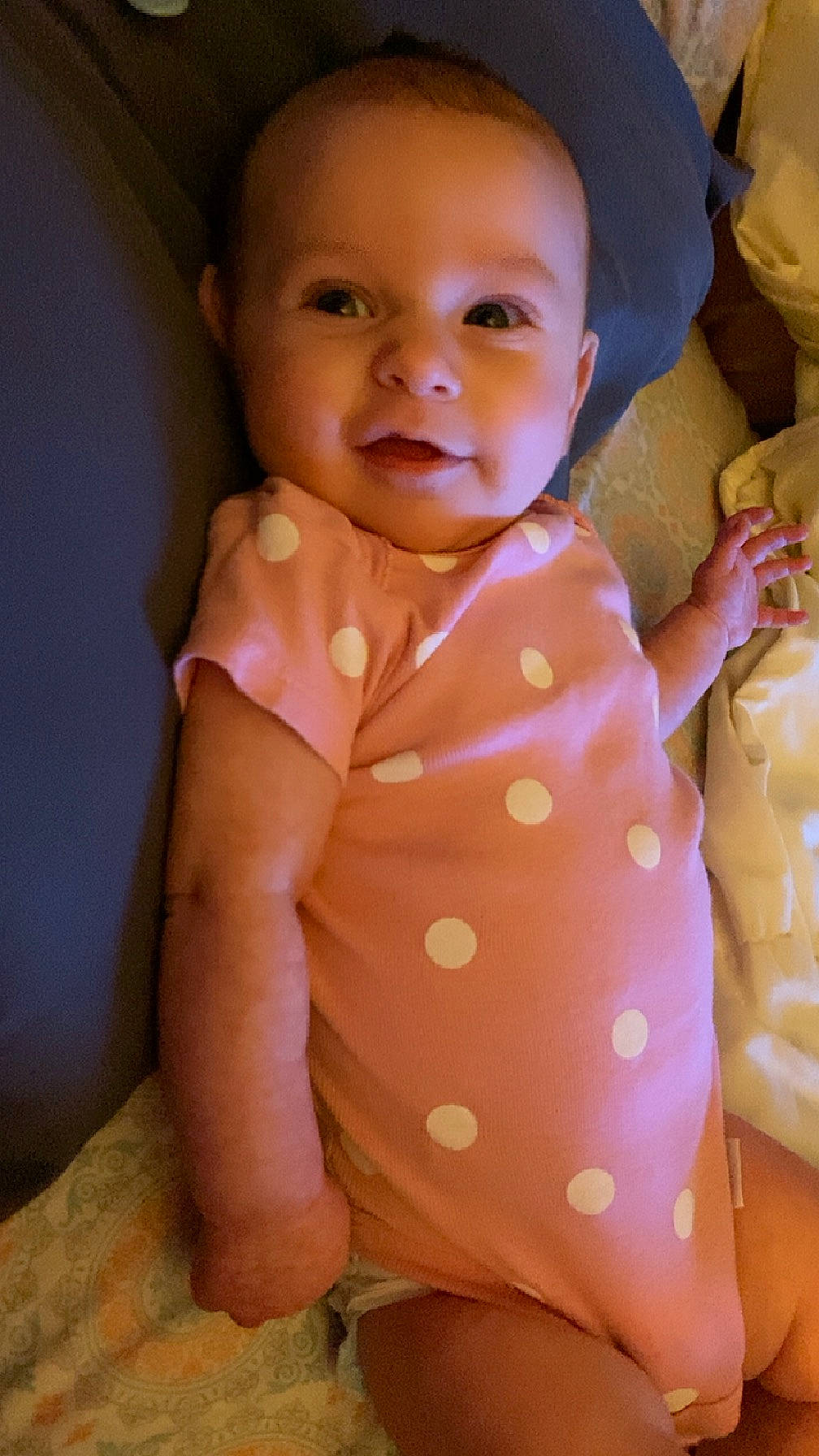 Raylee is registered to the contest to win money with this photo: arm, baby, baby_toddler_clothing, cheek, comfort, face, hand, happy, human_body, lip, mouth, neck, nose, orange, person, pink, skin, sleeve, smile, textile