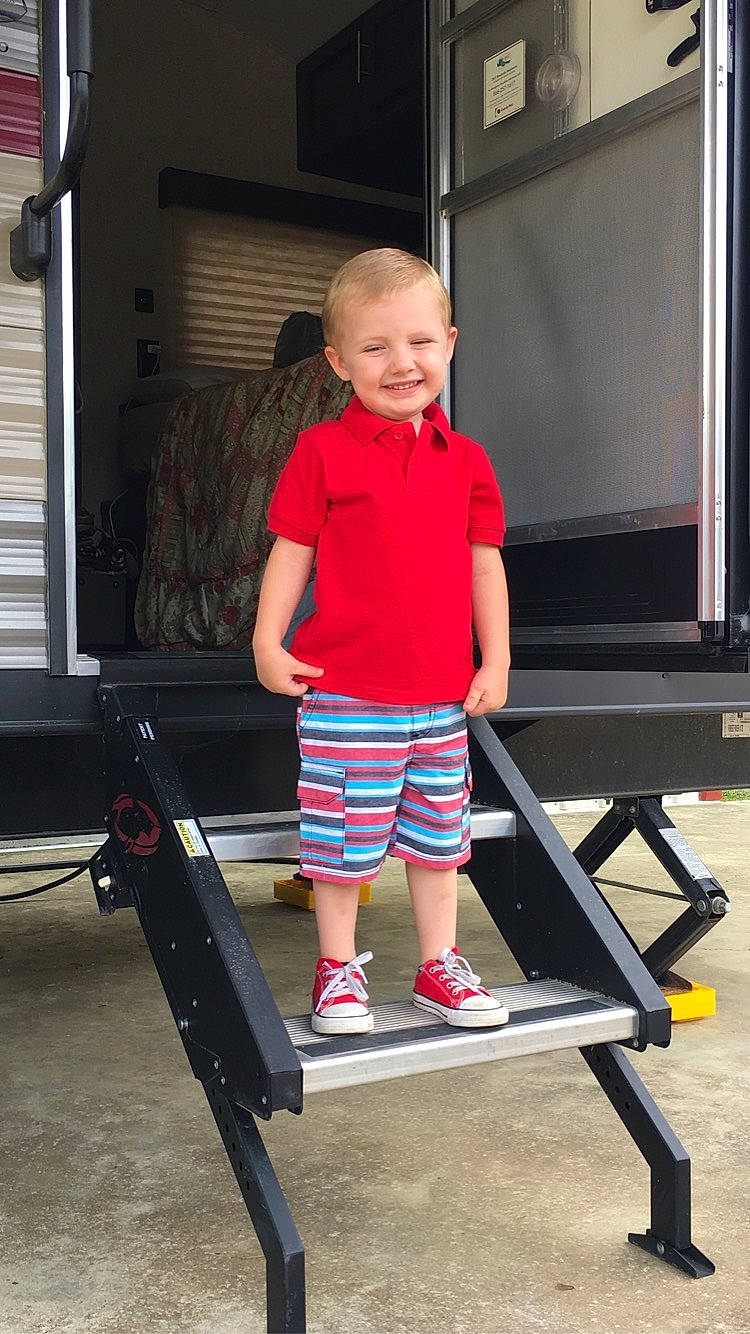 Logan is registered to the contest to win money with this photo: balance, child, exercise_equipment, furniture, human_leg, joint, joy, leg, person, physical_fitness, shoulder, sports_equipment, standing, t_shirt, toddler