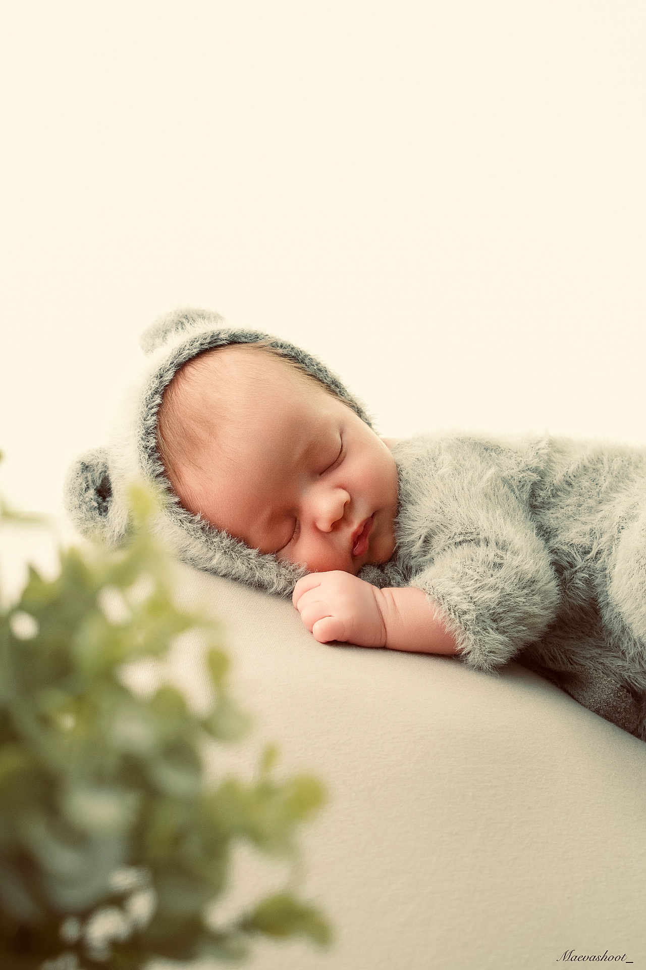 Raphaël participe au concours pour gagner de l'argent avec cette photo : baby, newborn, sleeping, fuzzy_outfit, hat, portrait, studio, soft_lighting, cream_background, pillow, hand, face, cheek, close_up, plant_blur, cozy, peaceful, cute, props, newborn_photography