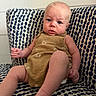 baby, child, infant, blue_eyes, brown_outfit, footwear, indoor, patterned_chair, seated, curious_expression, person, portrait, furniture, home, cute, young_child, skin, face, legs, hands