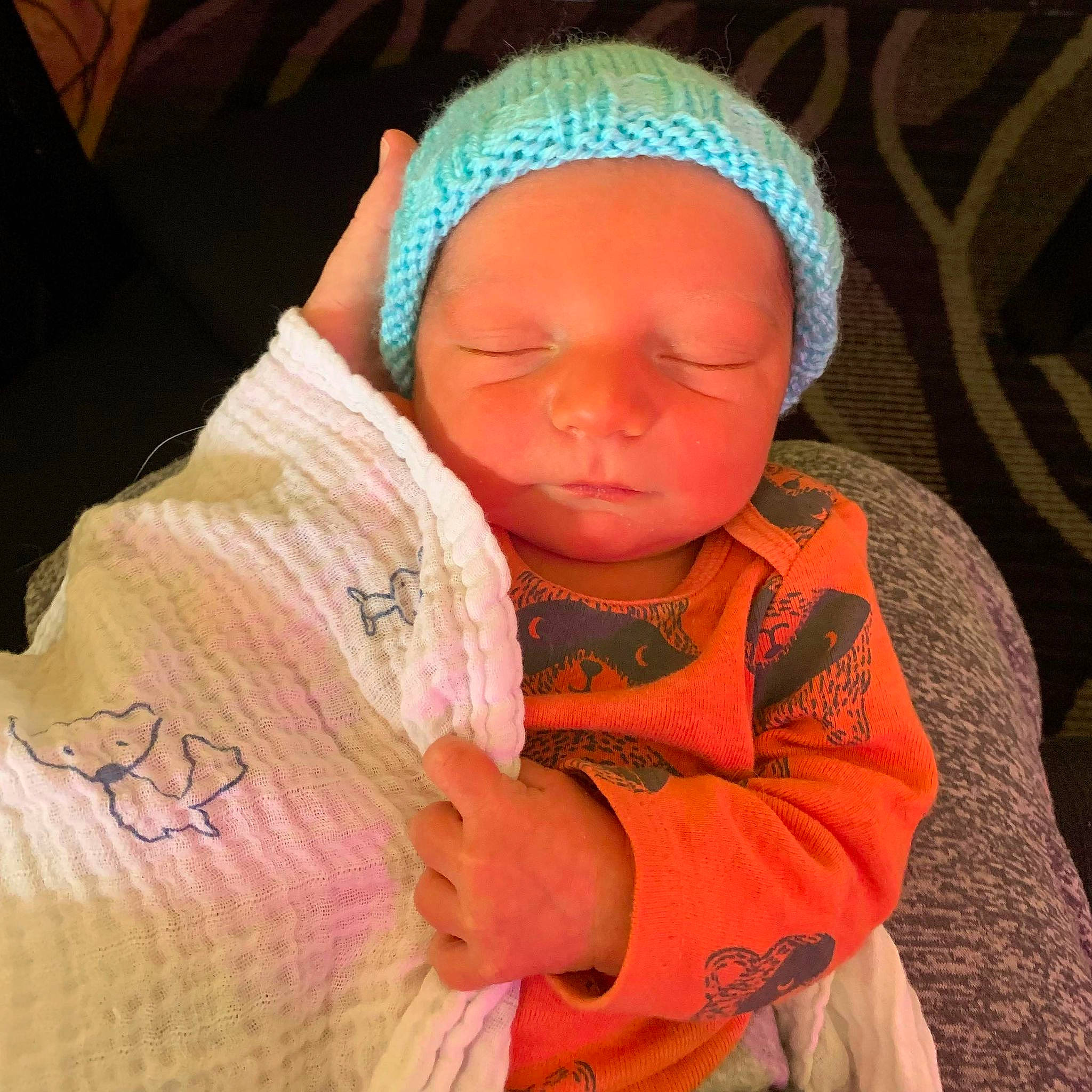 Jayden participe au concours pour gagner de l'argent avec cette photo : baby, baby_products, baby_sleeping, baby_toddler_clothing, cap, child, event, fashion_accessory, knit_cap, linens, magenta, orange, peach, person, pink, skin, sleeve, textile, thumb, toddler