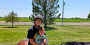 Oaklynn is registered to the contest to win money with this photo: adult, animal, child, daylight, family, fence, field, glasses, grass, helmet, horse, leisure, nature, outdoor, person, riding, rope, smile, sunny, tree