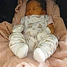 baby, sleeping, blanket, pajamas, infant, teddy_bear_pattern, cozy, soft, cute, child, newborn, resting, indoors, comfort, warm, clothing, face, head, footwear, peaceful