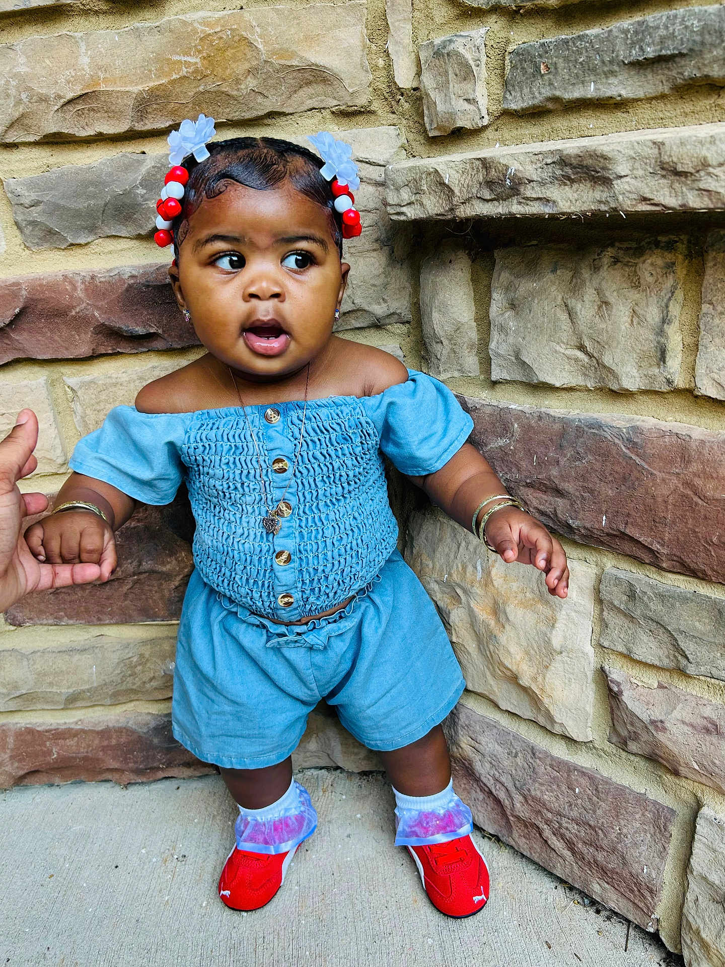 Samauni joined the competition — help win amazing prizes! toddler, child, blue_outfit, red_shoes, hair_accessories, stone_wall, sidewalk, hand_holding, bracelets, necklace, outdoor, curious_expression, standing, fashion, portrait, person, cute, young_child, casual_wear, colorful