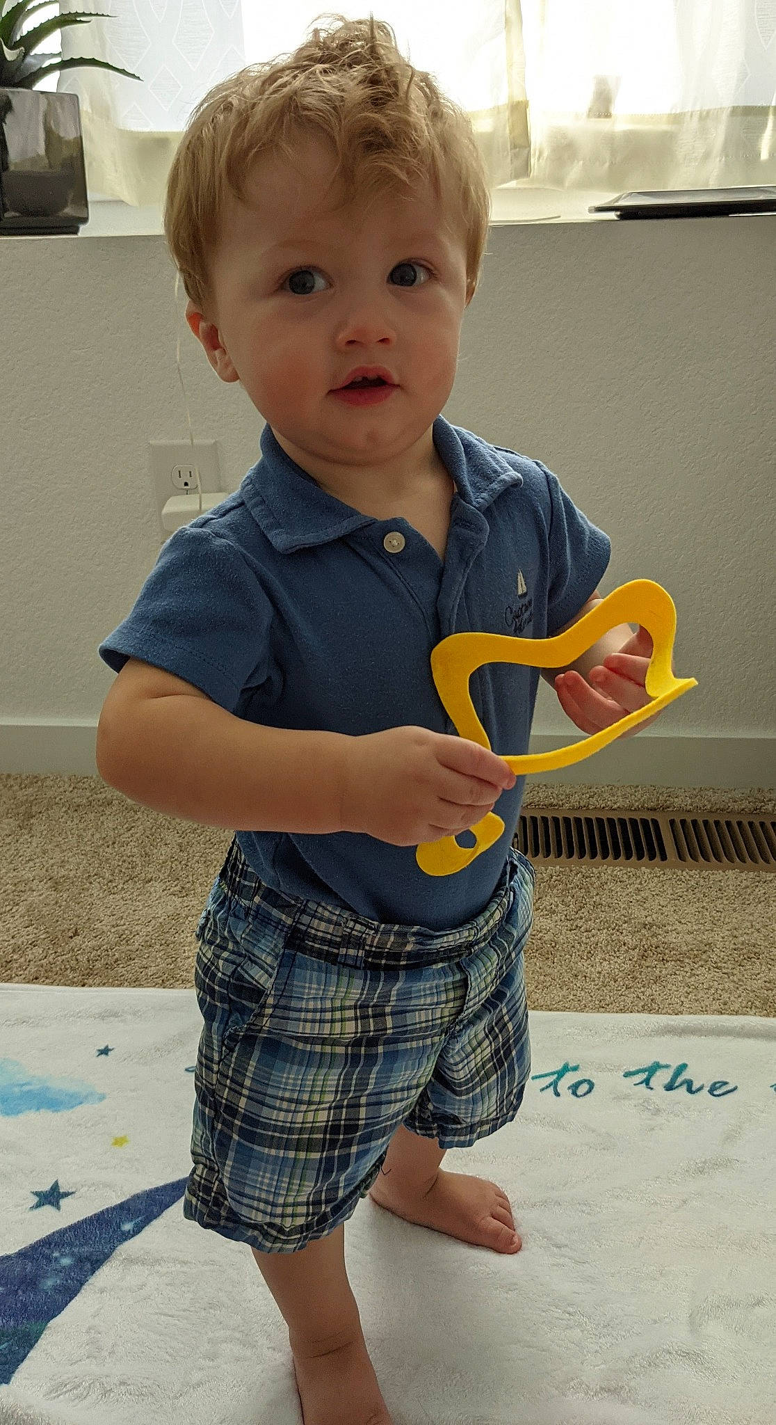 Jameson is registered to the contest to win money with this photo: baby, baby_toddler_clothing, blond, child, electric_blue, facial_expression, fun, happy, human_leg, pattern, person, photograph, plaid, sleeve, standing, street_fashion, t_shirt, tartan, thigh, toddler