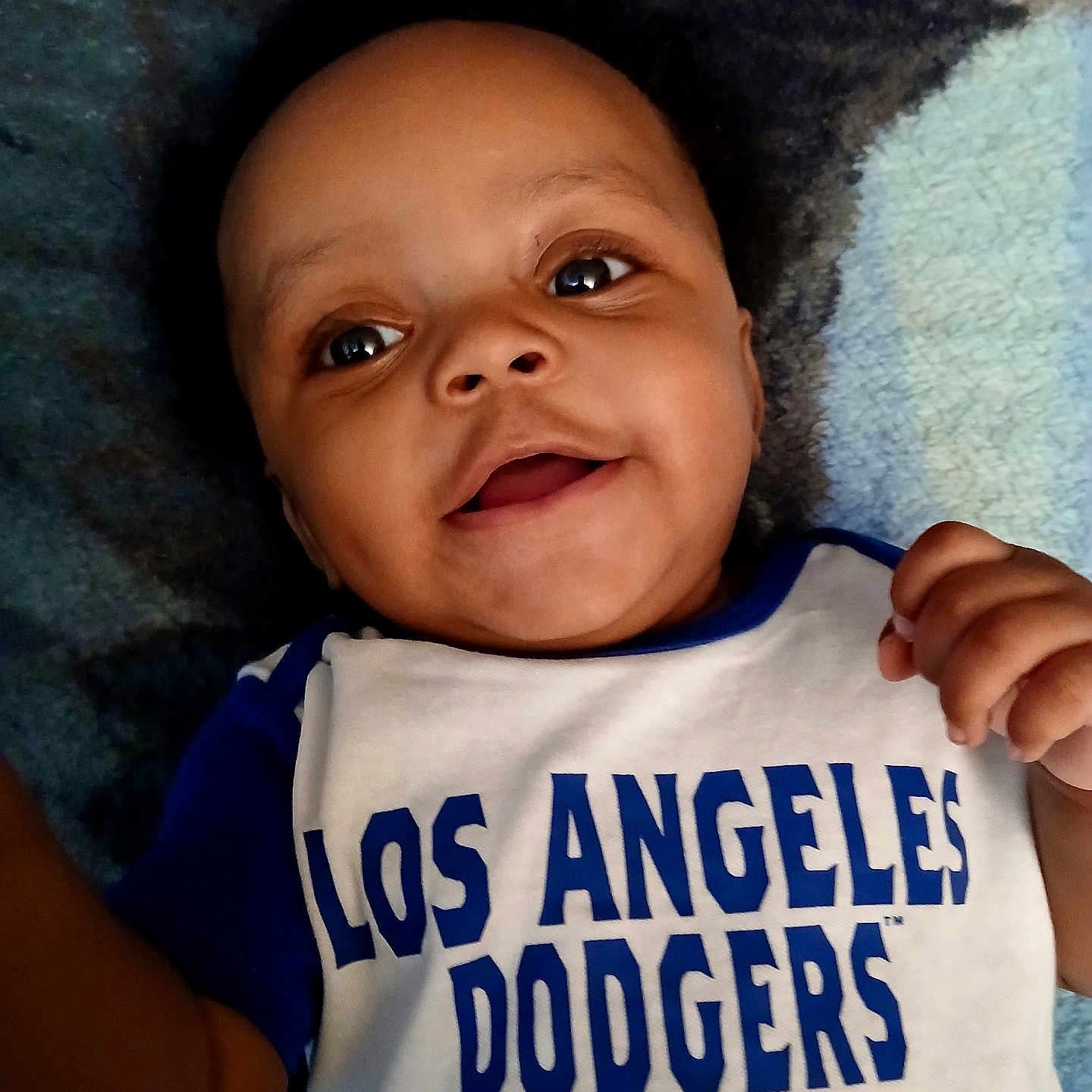 Robert joined the competition — help win amazing prizes! baby, baseball, blanket, child, close_up, clothing, eyes, face, hand, happy, indoor, infant, los_angeles_dodgers, lying_down, mouth, photography, portrait, shirt, smiling, sportswear