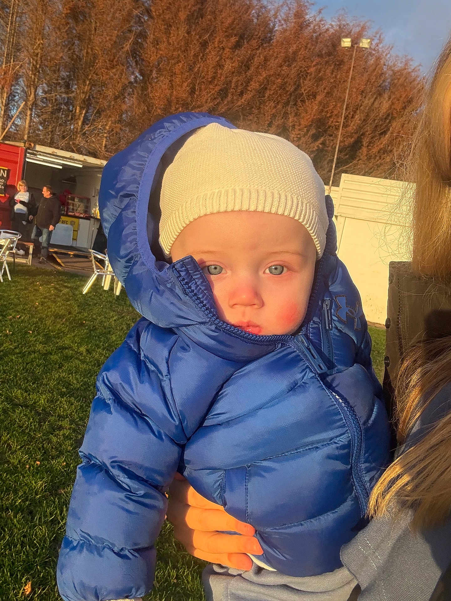Zarlo-Lee joined the competition — help win amazing prizes! baby, child, blue_jacket, knit_hat, outdoor, sunlight, grass, person, portrait, cold_weather, holding, face, winter_clothing, people, expression, nature, daylight, casual, young_child, warm_clothing
