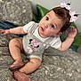baby, child, girl, sitting, pink_bows, minnie_mouse, outfit, sparkly_shoes, bedspread, patterned, curious, indoor, cute, infant, portrait, clothing, person, young_child, hair_accessories, closeup