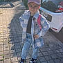 child, boy, cap, pink_cap, jacket, checkered_jacket, jeans, sneakers, sidewalk, car, white_car, backpack, pink_backpack, sunlight, shadow, plants, urban, outdoor, smile, pose