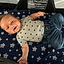 baby, smiling, infant, child, clothing, jeans, shirt, blanket, stars, happy, lying_down, cute, young_child, indoor, portrait, person, infant_clothing, casual, socks, baby_toys