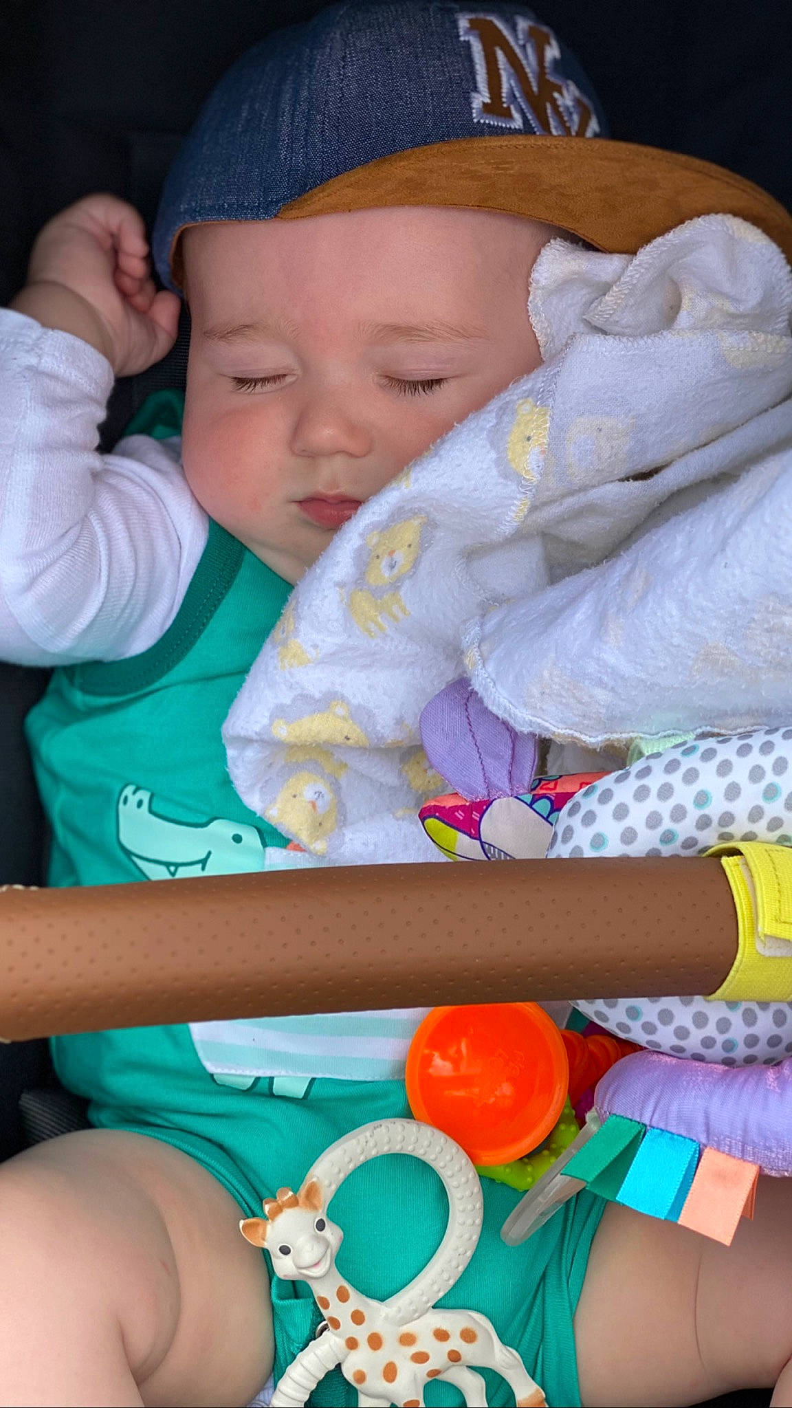 Matias is registered to the contest to win money with this photo: arm, baby, baby_toddler_clothing, blue, cap, cheek, facial_expression, finger, green, hand, happy, headwear, human, mouth, nose, organ, person, photograph, product, skin