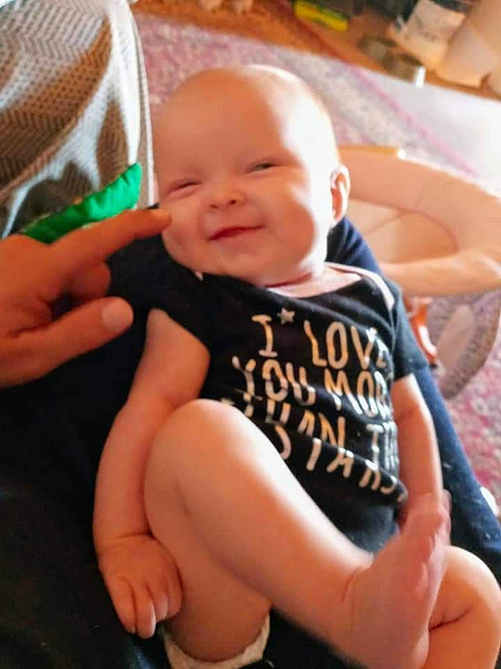 Arizona is registered to the contest to win money with this photo: arm, baby, baby_toddler_clothing, cheek, chin, comfort, eye, face, finger, hand, happy, head, human_body, iris, leg, mouth, person, skin, sleeve, smile