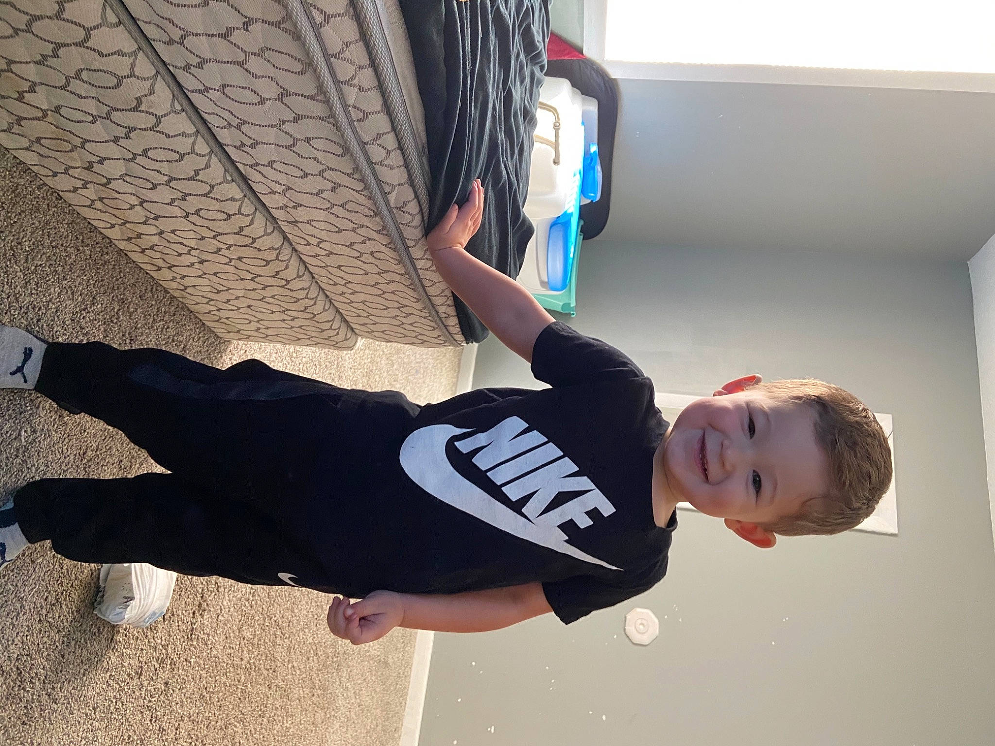 Caleb is registered to the contest to win money with this photo: automotive_design, automotive_tire, child, elbow, electric_blue, flooring, fun, happy, hat, human_leg, joy, knee, person, recreation, shorts, sportswear, t_shirt, thigh, tire, toddler