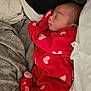 baby, newborn, sleeping, red_clothing, hearts_pattern, onesie, blanket, pillow, bedding, infant, cozy, portrait, bed, peaceful, closeup, soft_texture, cute, cuddly, indoors, resting