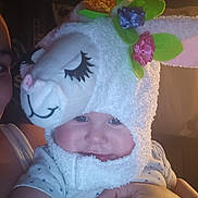 Stevie is registered to the contest to win money with this photo: baby, child, costume, hat, bunny, flowers, cute, smile, face, person, infant, hand, warm_lighting, indoor, plush, headwear, happy, soft_texture, portrait, cozy