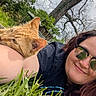 person, cat, grass, outdoor, tree, sunglasses, relaxing, nature, arm, ginger_cat, smile, leafy, daylight, casual, resting, closeup, happy, reflection, spring, friendship