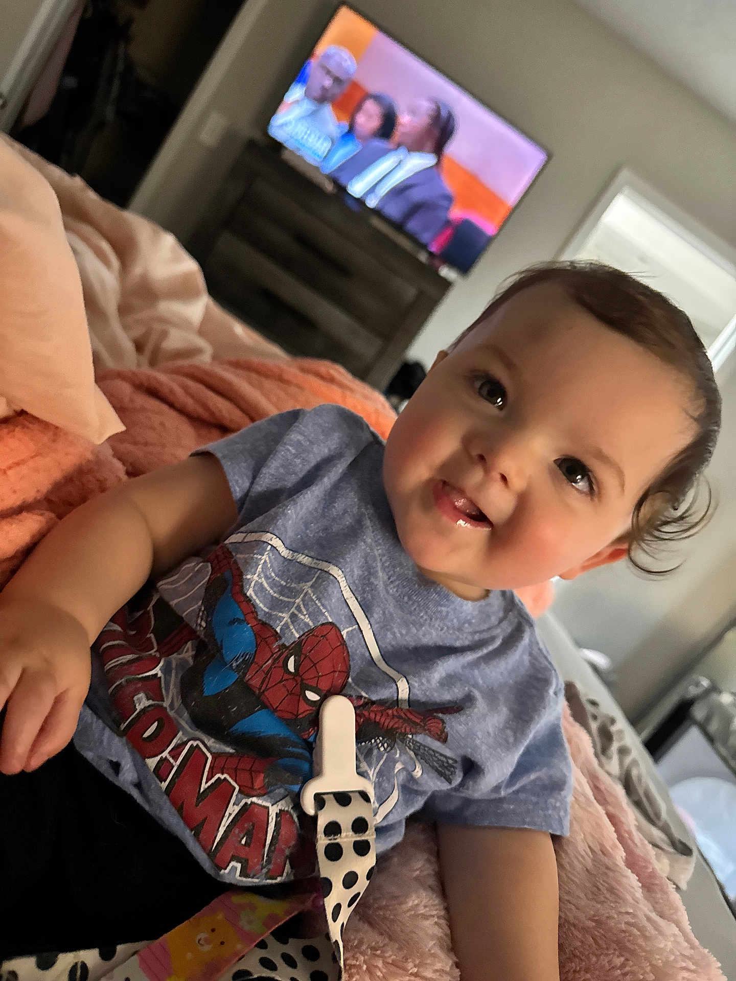 Ivy Jean joined the competition — help win amazing prizes! baby, child, toddler, spiderman, tshirt, smiling, drool, bed, blanket, indoor, television, furniture, person, face, curly_hair, cozy, relaxed, home, casual, happy