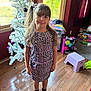 Madeline joined the competition — help win amazing prizes! child, girl, leopard_print, dress, purple_shoes, ponytail, smile, indoor, wooden_floor, christmas_tree, ornaments, window, natural_light, clothes, toys, stool, bag, carpet, party_bag, room