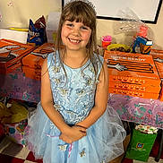 Madeline joined the competition — help win amazing prizes! child, girl, princess_dress, tiara, smiling, party, pizza_boxes, little_caesars, blue_dress, butterflies, indoors, table, food, snacks, happy, birthday_party, celebration, floor_tiles, gift_bag, decorations
