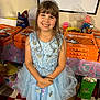 child, girl, princess_dress, tiara, smiling, party, pizza_boxes, little_caesars, blue_dress, butterflies, indoors, table, food, snacks, happy, birthday_party, celebration, floor_tiles, gift_bag, decorations