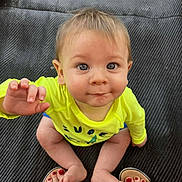 Lincoln is registered to the contest to win money with this photo: baby, child, infant, yellow_shirt, blue_shorts, barefoot, toes, red_nail_polish, feet, playful, curious, sitting, mat, texture, indoors, portrait, face, hand, eyes, expression