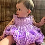 baby, child, dress, lavender, flowers, sitting, couch, patterned_fabric, curious, portrait, infant, cute, indoor, skin, head, face, arm, leg, birthmark, clothing