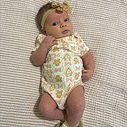 Isabelle is registered to the contest to win money with this photo: baby, baby_clothing, blanket, bow, bows, child, curious, cute, gingerbread_men, headband, indoor, infant, lying_down, newborn, onesie, pattern, person, skin, socks, soft_texture