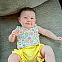 arm, baby, child, clothing, comfortable, couch, cute, face, floral_top, happy, indoors, infant, leg, portrait, sitting, skin, smile, textured_fabric, toddler, yellow_shorts