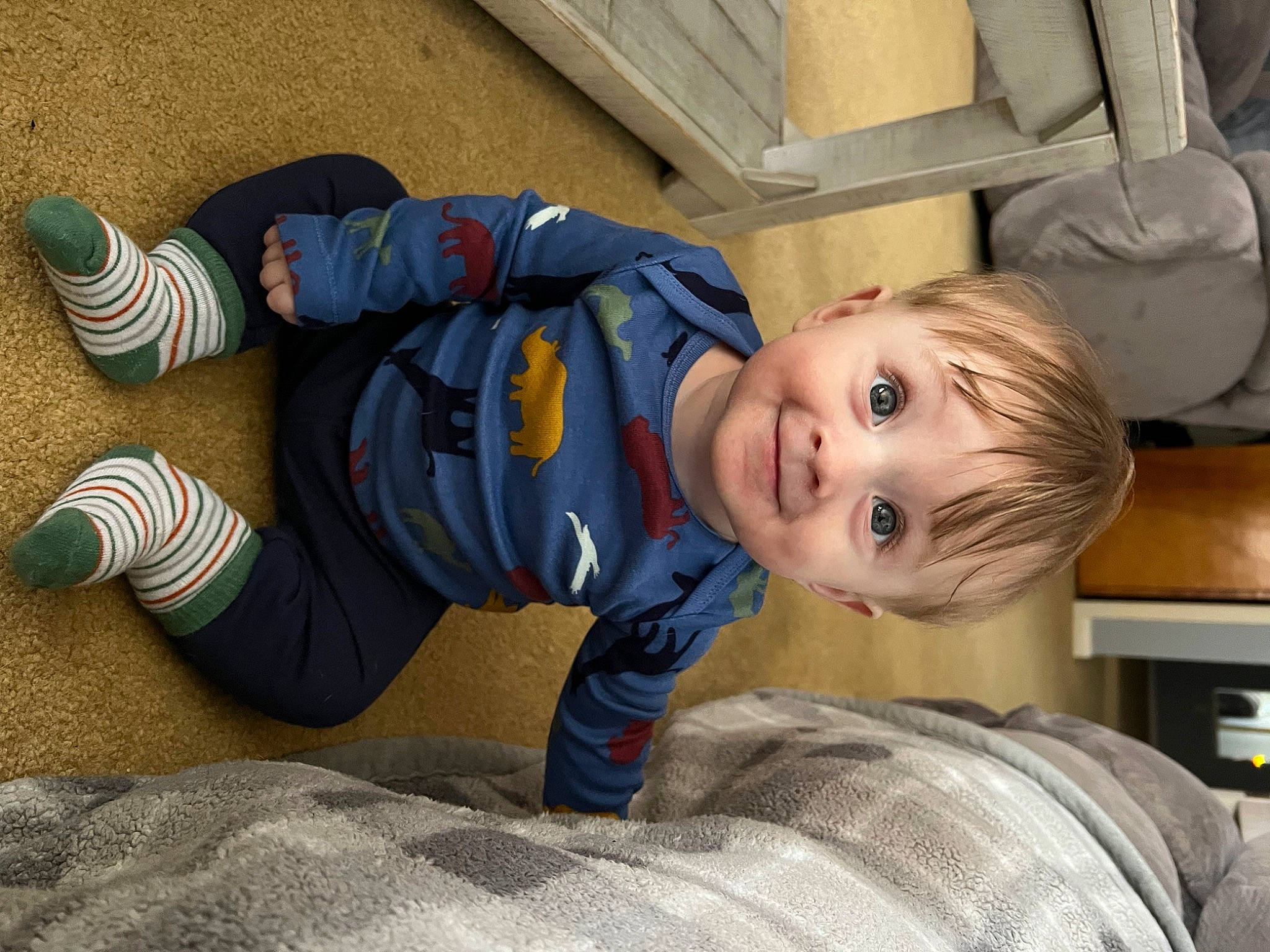 Jameson is registered to the contest to win money with this photo: baby, baby_toddler_clothing, child, comfort, electric_blue, facial_expression, flooring, foot, fun, grass, joy, leg, leisure, person, sitting, sleeve, smile, sock, standing, toddler