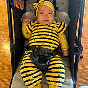 Susej joined the competition — help win amazing prizes! baby, child, infant, bee_costume, yellow, black, stripes, headband, antennae, wings, bow, stroller, harness, seated, portrait, indoors, wooden_floor, cute, costume, face