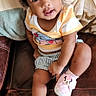 baby, child, couch, curly_hair, flower, furniture, hair_clips, indoors, minnie_mouse, photography, pink_shoes, portrait, shirt, shorts, sitting, smiling, sneakers, striped_clothing, toddler, wide_eyed