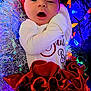 baby, infant, holiday, christmas, headband, red_skirt, lights, tinsel, festive, cute, smiling, face, clothing, celebration, colorful, indoors, person, portrait, newborn, cheerful
