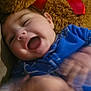 baby, child, teddy_bear, blue_clothing, smile, happy, laughing, hands, motion_blur, plush_toy, red_bow, soft_texture, face, infant, cute, indoor, closeup, joy, playful, cozy