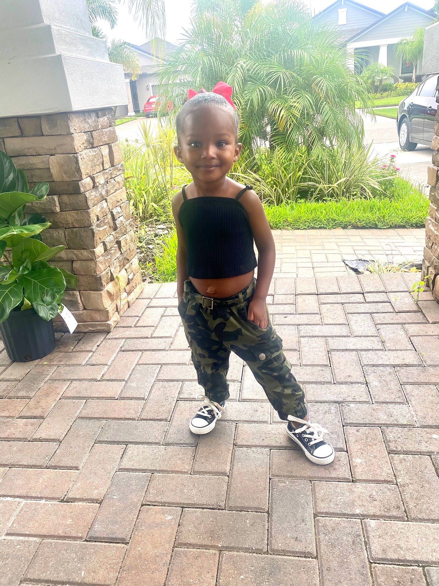 Vanya is registered to the contest to win money with this photo: asphalt, baby, baby_toddler_clothing, building, eye, floor, flooring, flowerpot, grass, happy, house, joy, leaf, leisure, person, plant, road_surface, smile, standing, t_shirt