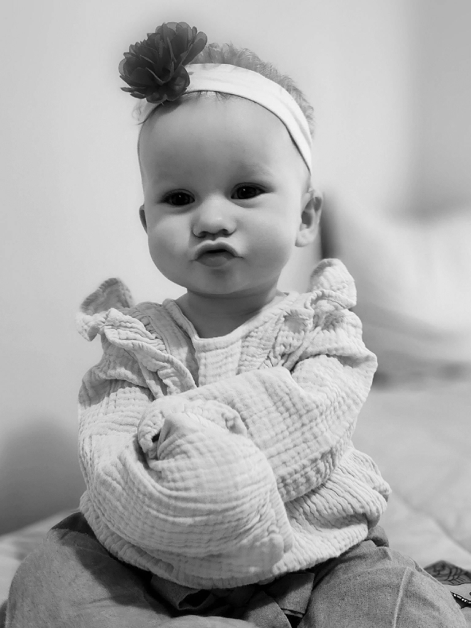 Iris is registered to the contest to win money with this photo: baby, black_and_white, cheek, comfort, eye, eyelash, flash_photography, gesture, happy, headgear, human_body, iris, lip, monochrome, monochrome_photography, person, photograph, skin, sleeve, style