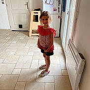 Diane a rejoint le concours — aidez-le/la à gagner de superbes lots ! child, clothing, face, female, footwear, furniture, girl, head, indoors, interiordesign, pants, person, sandal, shoe, shorts, skirt, sleeve, standing, table, wood