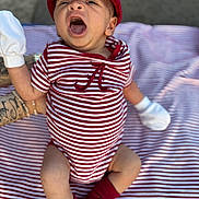 Cylas joined the competition — help win amazing prizes! baby, infant, striped_clothing, red_cap, white_mittens, red_socks, blanket, tattooed_arm, yawning, outdoor, person, cute, closeup, expression, sitting, striped_blanket, child, casual_wear, baby_fashion, portrait