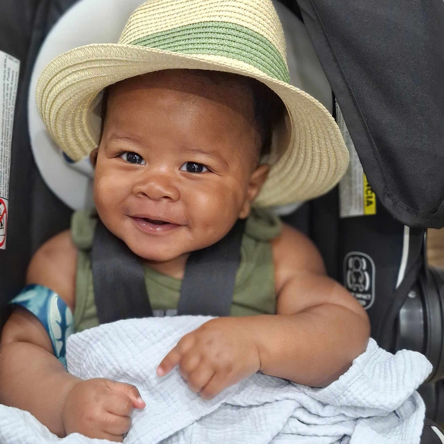 Kenari is registered to the contest to win money with this photo: baby, child, infant, smiling, happy, portrait, car_seat, hat, straw_hat, blanket, harness, seated, indoor, close_up, face, arms, hands, clothing, photography, cute
