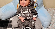 Amaziah is registered to the contest to win money with this photo: baby, infant, child, hoodie, clothing, sitting, smiling, tongue_out, face, eyes, hands, feet, baby_chair, pillow, blanket, indoor, wall, cute, cozy, portrait