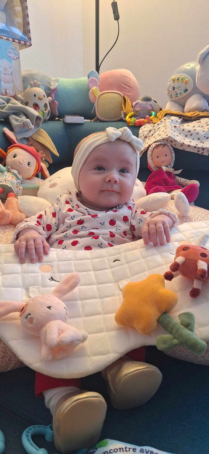 Laïa a rejoint le concours — aidez-le/la à gagner de superbes lots ! baby, child, plush_toys, doll, headband, couch, clothing, footwear, toy, smile, indoor, soft_toy, blanket, cute, infant, face, person, seated, decor, playtime