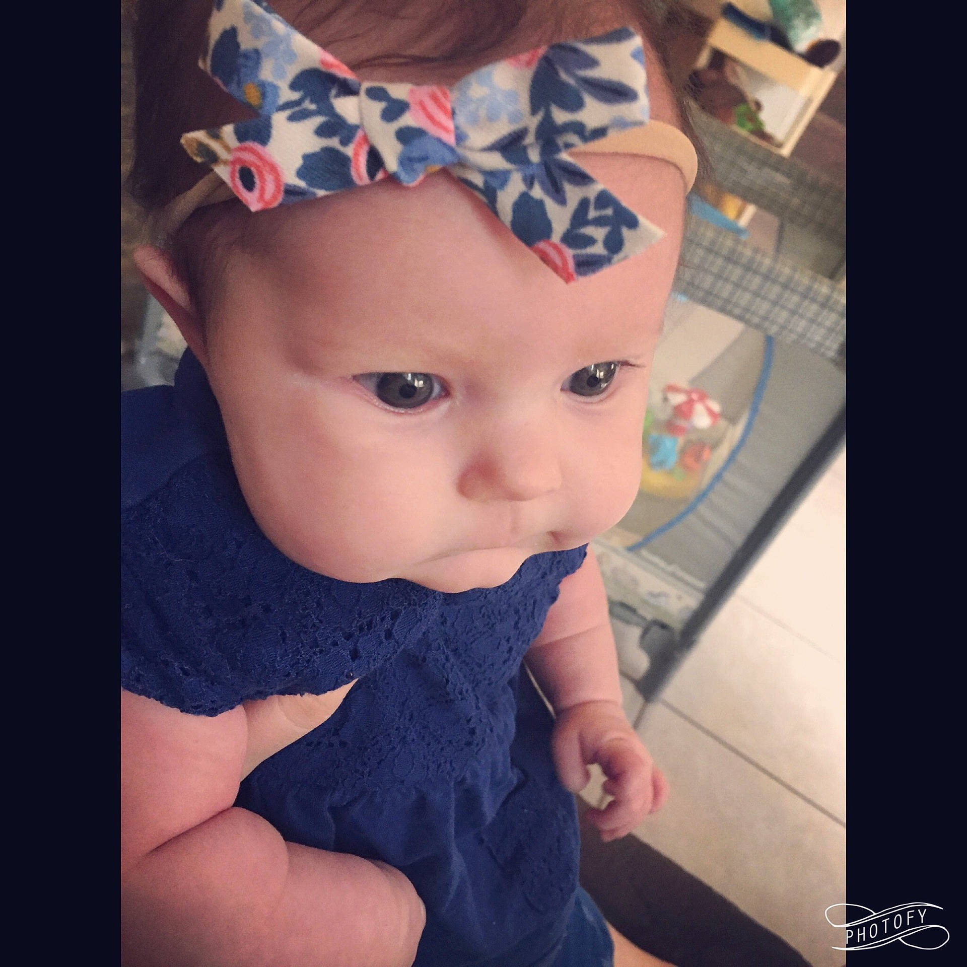 Beatrix is registered to the contest to win money with this photo: blue, child, clothing, dress, ear, eye, face, fashion_accessory, hair_accessory, head, infant, nose, organ, pattern, person, toddler