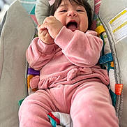 Akemy joined the competition — help win amazing prizes! baby, pink_clothing, smiling, happy, infant, bows, child, cushion, colorful, seat, indoors, cute, clapping, portrait, soft_fabric, playful, young_child, cheerful, closeup, person