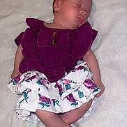 Kaylonni is registered to the contest to win money with this photo: adorable, baby, blanket, child, closed_eyes, cute, floral_skirt, heart_shapes, indoors, infant, lying_down, newborn, peaceful, portrait, purple_clothing, resting, skin, sleeping, soft_texture, tiny_feet